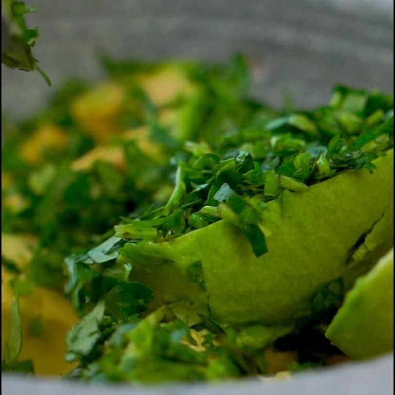 Close-up of fresh avocado chunks and chopped cilantro, ready for guacamole at Padrino's.